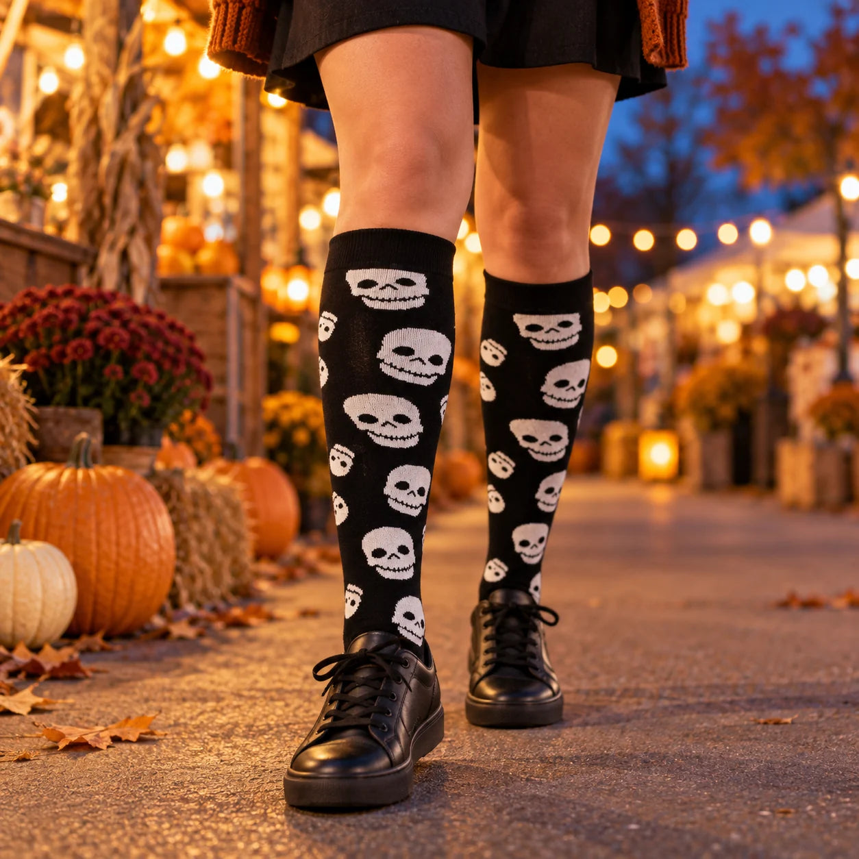 Grinning-skull knee-high socks worn at an autumn evening market